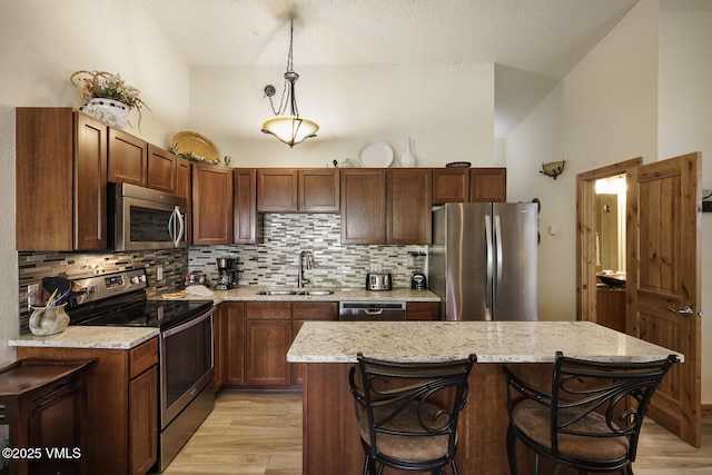 531 E Lionshead Cir Unit 303, Vail, CO 81657 - kitchen featuring stainless steel appliances, a sink, light wood-style floors, backsplash, and a textured ceiling