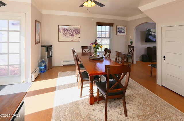 546 Grand Ave, Eagle, CO 81631 - dining room featuring a baseboard radiator, light wood finished floors, a ceiling fan, and arched walkways