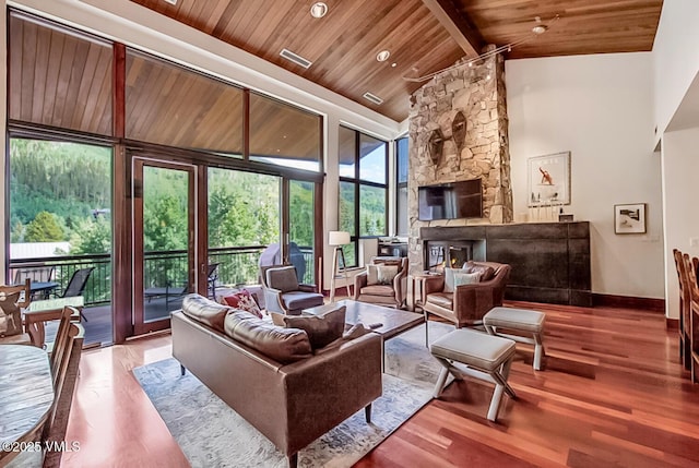 1325 Westhaven Dr Unit A302, Vail, CO 81657 - living room with a wooden ceiling with exposed beams, wood finished floors, a stone fireplace, and high vaulted ceiling