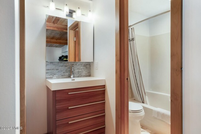 full bathroom featuring shower / tub combo with curtain, vanity, decorative backsplash, and toilet