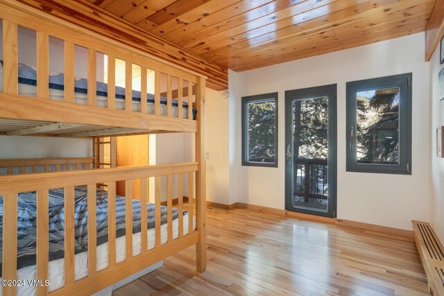 bedroom with light hardwood / wood-style flooring and wooden ceiling