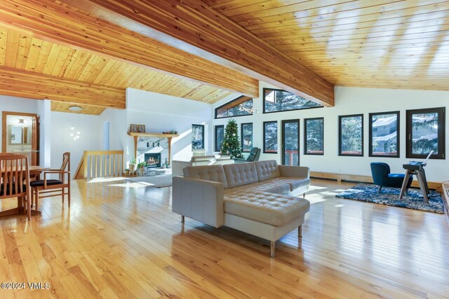 living room with beamed ceiling, high vaulted ceiling, light hardwood / wood-style flooring, and wooden ceiling