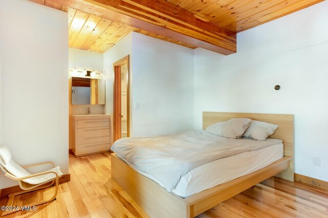 bedroom featuring beam ceiling, wood ceiling, and light hardwood / wood-style flooring