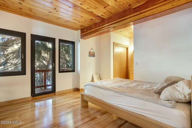 bedroom with wood ceiling, light hardwood / wood-style flooring, and beamed ceiling