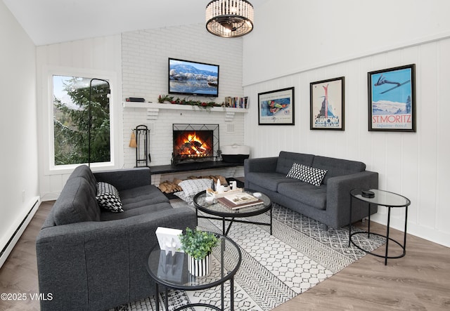 4480 Timber Falls Ct Unit 1507, Vail, CO 81657 - living area featuring vaulted ceiling, a baseboard radiator, a fireplace, wood finished floors, and baseboards