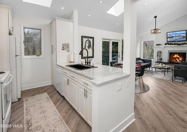 4480 Timber Falls Ct Unit 1507, Vail, CO 81657 - kitchen featuring a skylight, a sink, vaulted ceiling, white appliances, and a fireplace