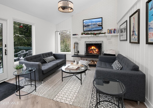 4480 Timber Falls Ct Unit 1507, Vail, CO 81657 - living room featuring vaulted ceiling, wood finished floors, and a brick fireplace