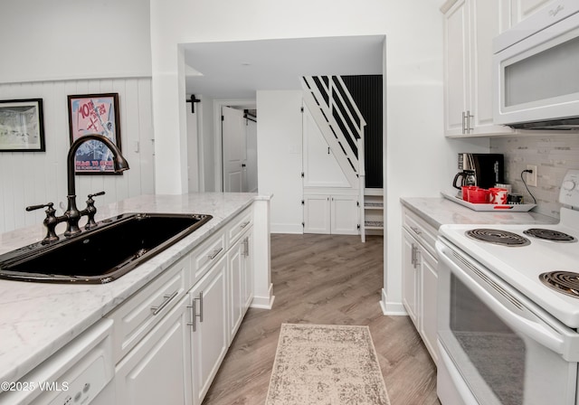 4480 Timber Falls Ct Unit 1507, Vail, CO 81657 - kitchen with white appliances, a sink, white cabinets, light wood-type flooring, and backsplash