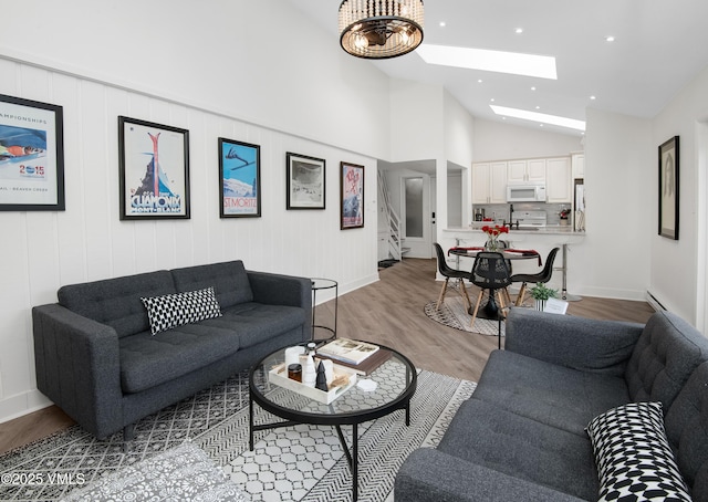 4480 Timber Falls Ct Unit 1507, Vail, CO 81657 - living room featuring a skylight, lofted ceiling, light wood finished floors, a baseboard radiator, and recessed lighting