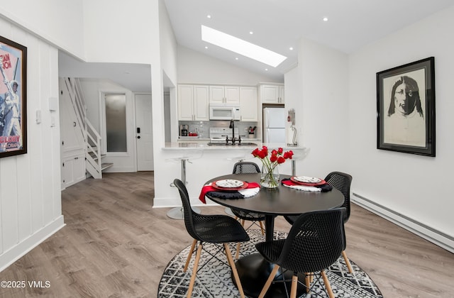 4480 Timber Falls Ct Unit 1507, Vail, CO 81657 - dining room featuring a skylight, vaulted ceiling, baseboard heating, stairway, and light wood-type flooring