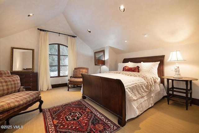 carpeted bedroom featuring lofted ceiling and baseboards