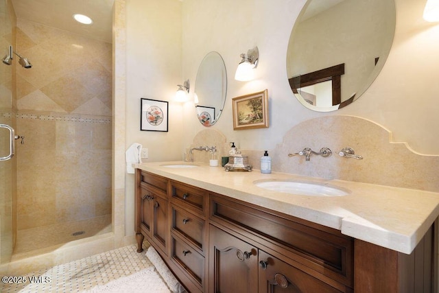 bathroom with double vanity, a shower stall, and a sink