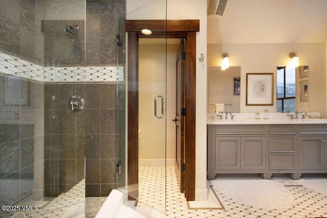 bathroom featuring double vanity, tile patterned flooring, a stall shower, and a sink