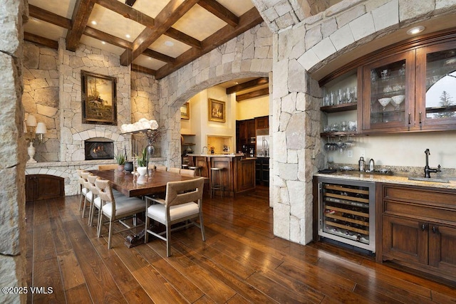 dining room with beamed ceiling, wet bar, dark wood-style floors, and beverage cooler