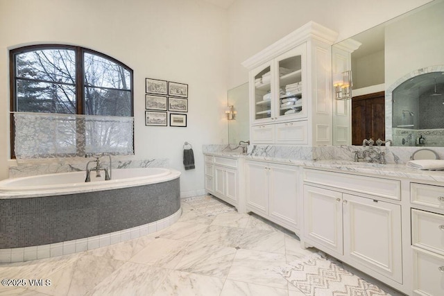 full bathroom with vanity, a bath, and marble finish floor