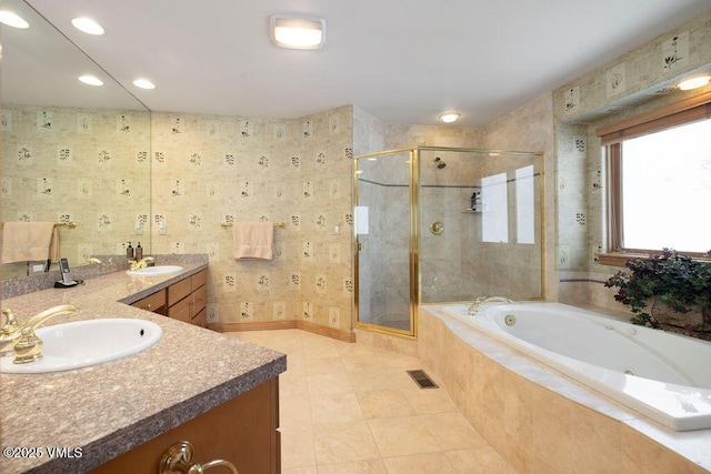 full bathroom with visible vents, a garden tub, double vanity, a shower stall, and a sink