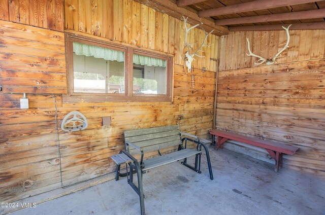 interior space with beam ceiling and wood walls