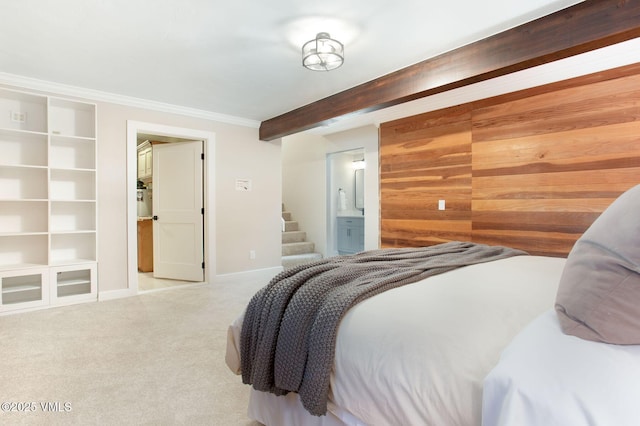 carpeted bedroom with ensuite bath, wooden walls, and ornamental molding