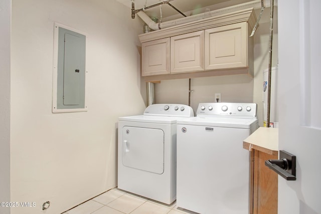 washroom with light tile patterned floors, cabinet space, electric panel, and washer and clothes dryer