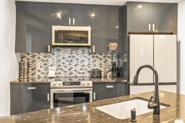 2940 Basingdale Blvd Unit 2, Vail, CO 81657 - kitchen featuring appliances with stainless steel finishes, a sink, decorative backsplash, and dark stone counters