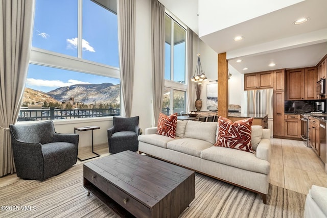 living area featuring a high ceiling, a mountain view, and recessed lighting