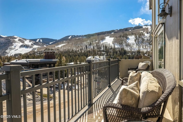 snow covered back of property featuring a mountain view