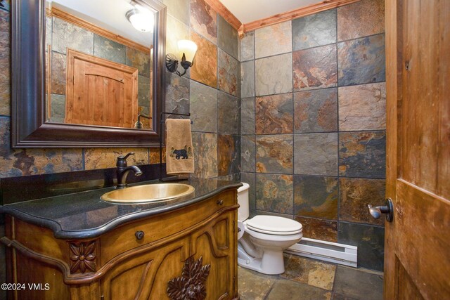 bathroom with vanity, ornamental molding, toilet, and baseboard heating