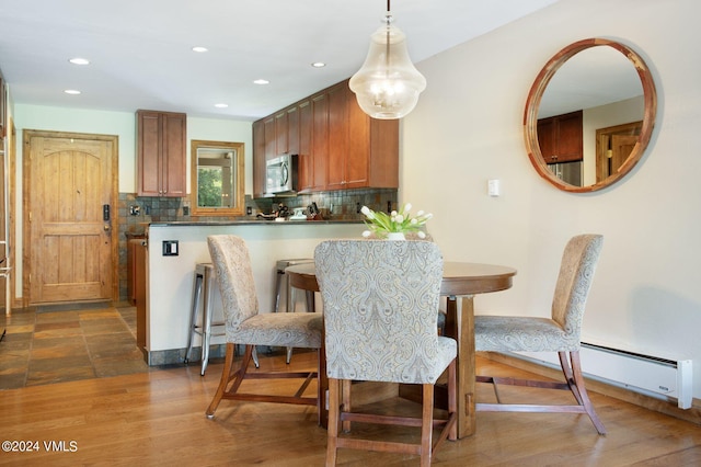 dining space featuring a baseboard radiator and dark wood-type flooring