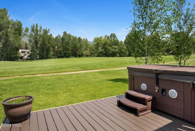 wooden terrace featuring a yard and a hot tub