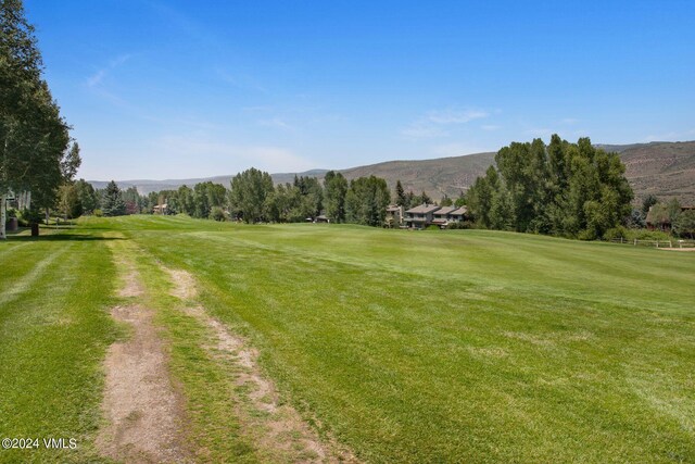 surrounding community featuring a mountain view and a lawn