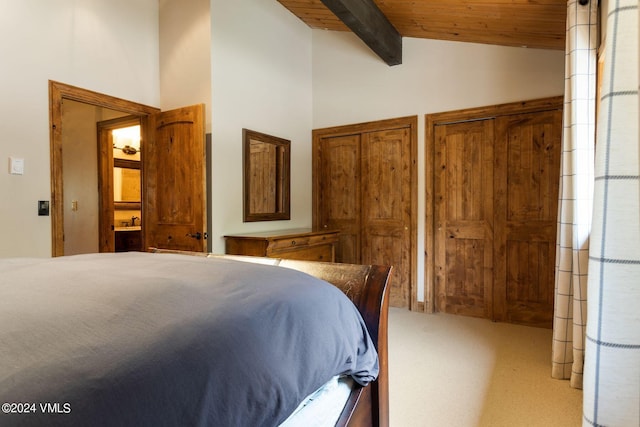 carpeted bedroom with wood ceiling, lofted ceiling with beams, and two closets