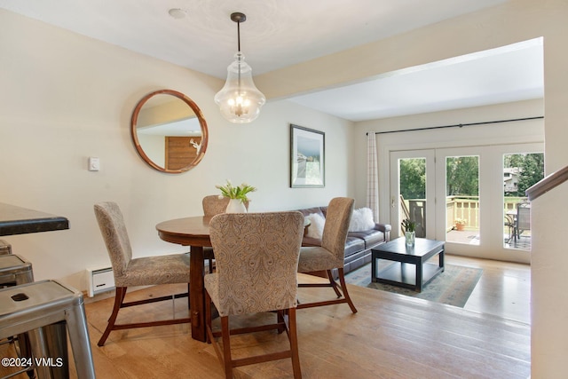 dining area with a baseboard radiator and light hardwood / wood-style flooring