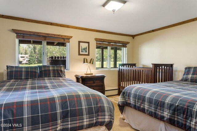 bedroom featuring a baseboard radiator, ornamental molding, and light carpet