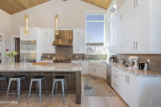 2682 E Haystacker Dr, Eagle, CO 81631 - kitchen with appliances with stainless steel finishes, lofted ceiling, light wood-style floors, a kitchen breakfast bar, and white cabinetry