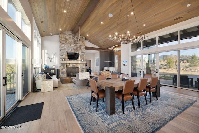 2682 E Haystacker Dr, Eagle, CO 81631 - dining area with high vaulted ceiling, a chandelier, light wood-style flooring, a fireplace, and a wood ceiling with exposed beams