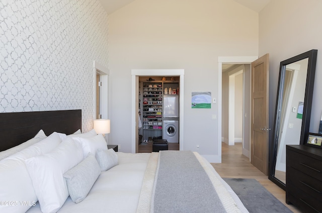2682 E Haystacker Dr, Eagle, CO 81631 - bedroom with an accent wall, high vaulted ceiling, a spacious closet, light wood-style floors, and wallpapered walls