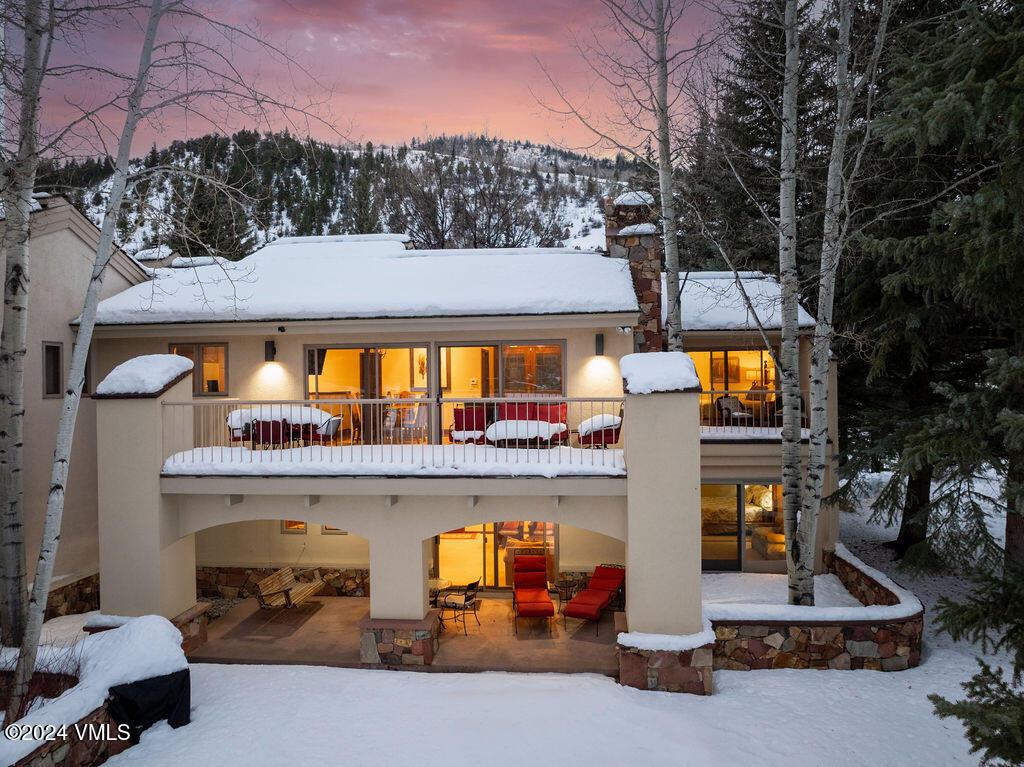 snow covered house featuring a balcony and a mountain view