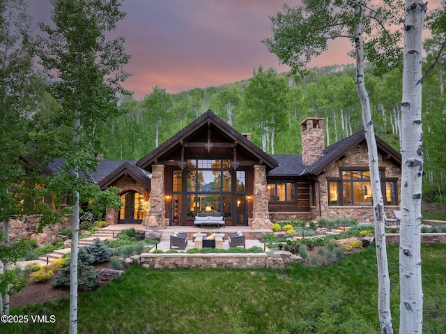 1724 Paintbrush, Avon, CO 81620 - back of property featuring an outdoor hangout area, stone siding, a chimney, french doors, and a patio area