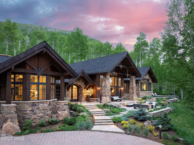 1724 Paintbrush, Avon, CO 81620 - view of front of home with stone siding, a patio area, outdoor lounge area, roof with shingles, and french doors