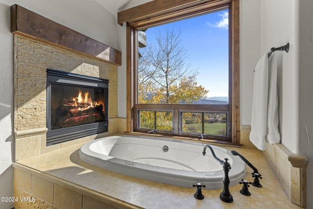 bathroom with tiled tub and vaulted ceiling