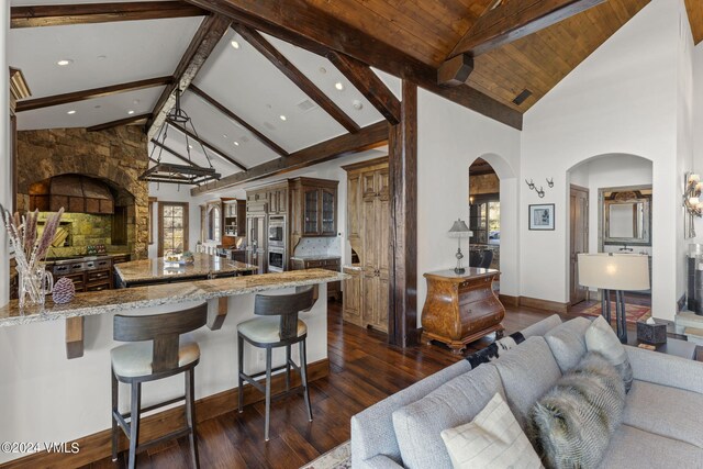 kitchen featuring beamed ceiling, dark hardwood / wood-style floors, backsplash, and a kitchen breakfast bar