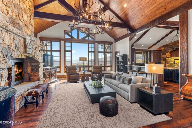 living room featuring wood ceiling, a stone fireplace, dark wood-type flooring, and beamed ceiling