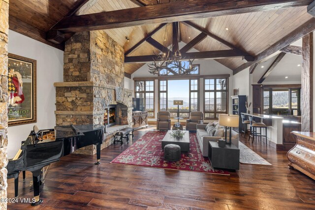 living room featuring wood ceiling, hardwood / wood-style floors, a stone fireplace, and beamed ceiling