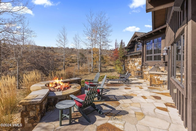 view of patio with exterior kitchen and an outdoor fire pit