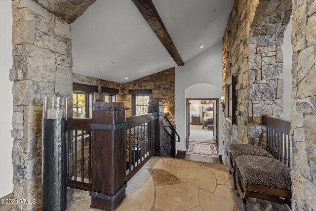 corridor featuring vaulted ceiling with beams