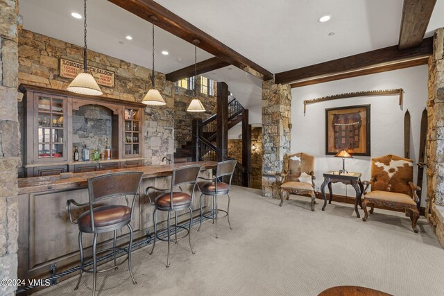 bar featuring beamed ceiling, pendant lighting, and light colored carpet