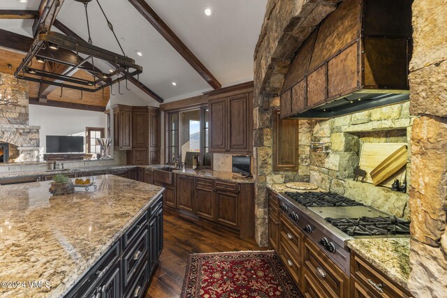 kitchen with dark hardwood / wood-style floors, stainless steel gas stovetop, vaulted ceiling with beams, decorative backsplash, and dark brown cabinetry