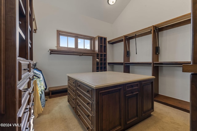 spacious closet with light carpet and vaulted ceiling