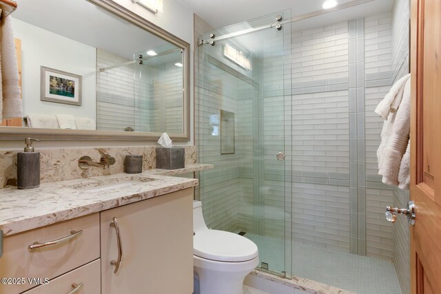 bathroom featuring vanity, toilet, and walk in shower