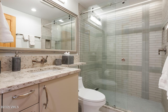 bathroom featuring vanity, an enclosed shower, and toilet